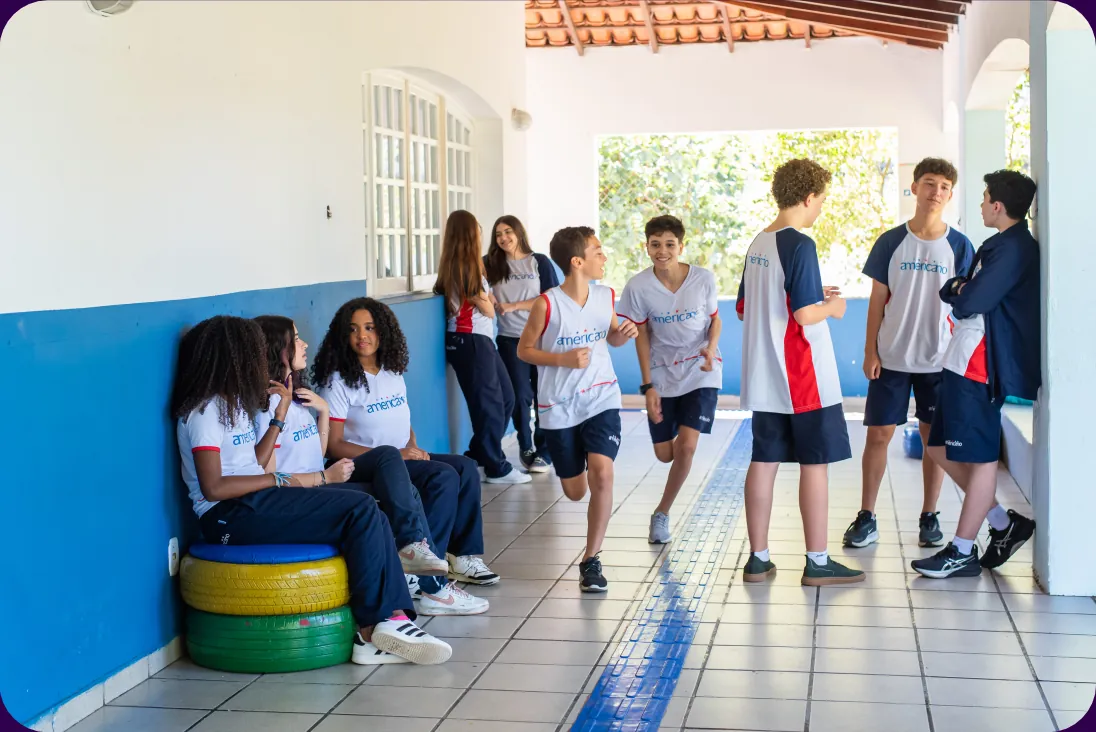 Alunos conversando e caminhando no corredor do Colégio Americano Serra